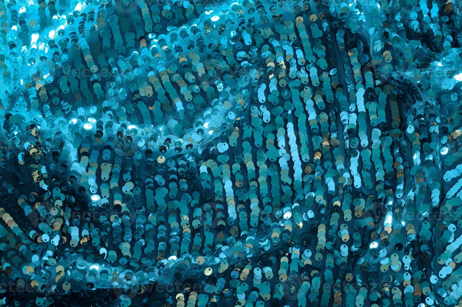 tissu bleu turquoise brillant et scintillant avec des sequins. fond abstrait. événements, célébrations, noël, nouvel an. toile de fond tendance. photo