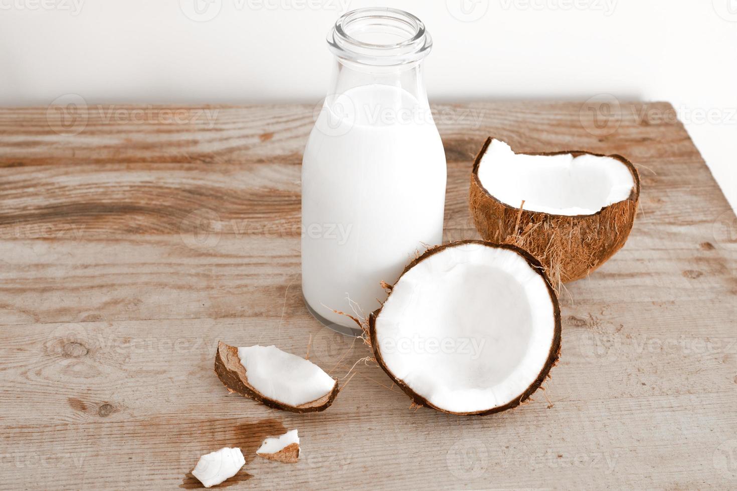 lait de coco frais dans une bouteille en verre, boisson saine végétalienne non laitière. table en bois, gros plan. photo