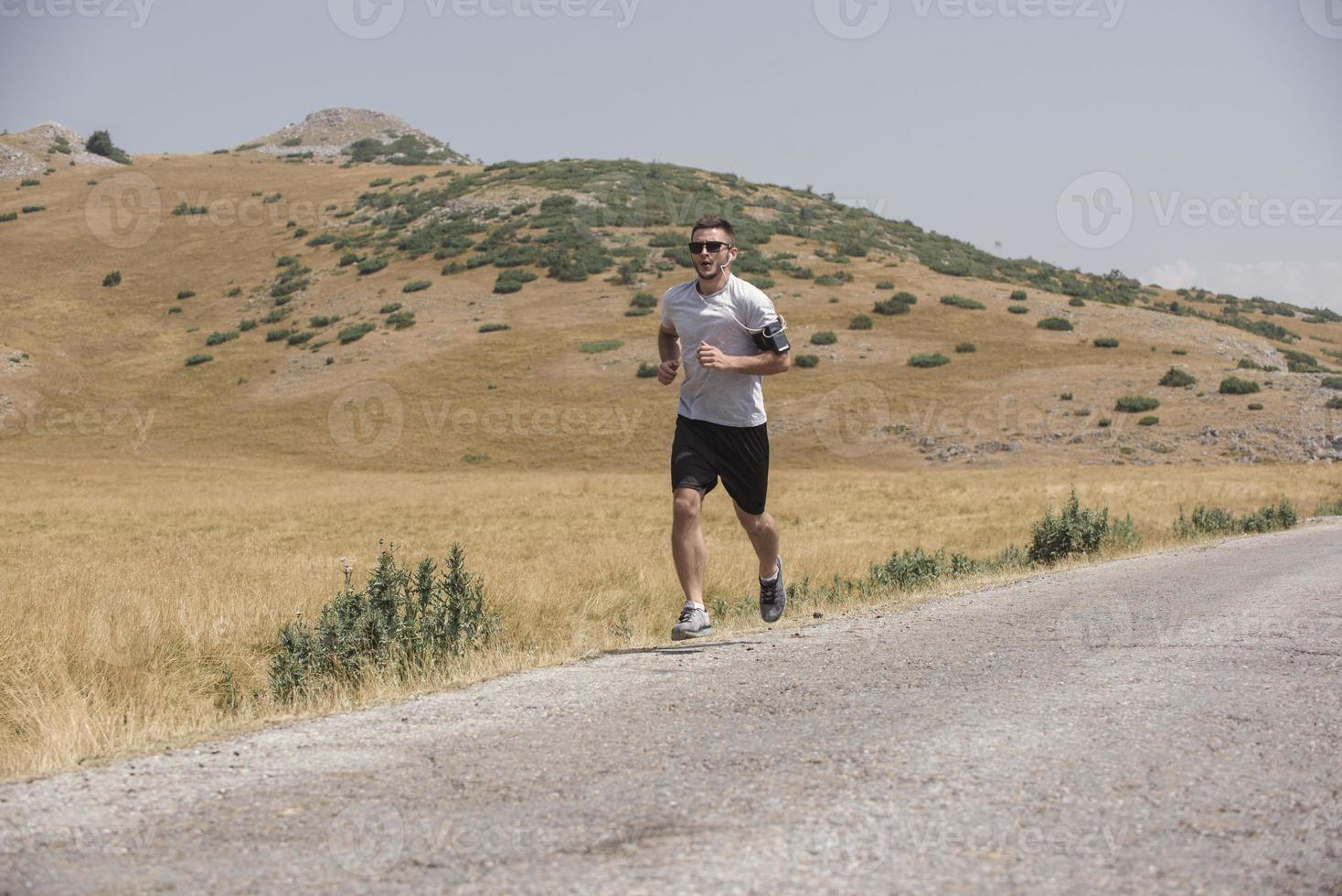 coureur d'homme sportif courant sur le plateau de montagne en été photo