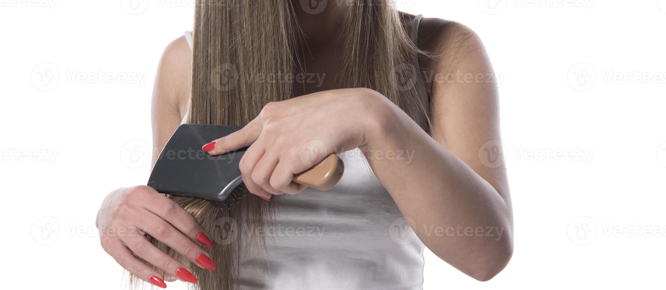 belle jeune femme aux cheveux longs se peignant les cheveux le matin. concept de soins capillaires. photo