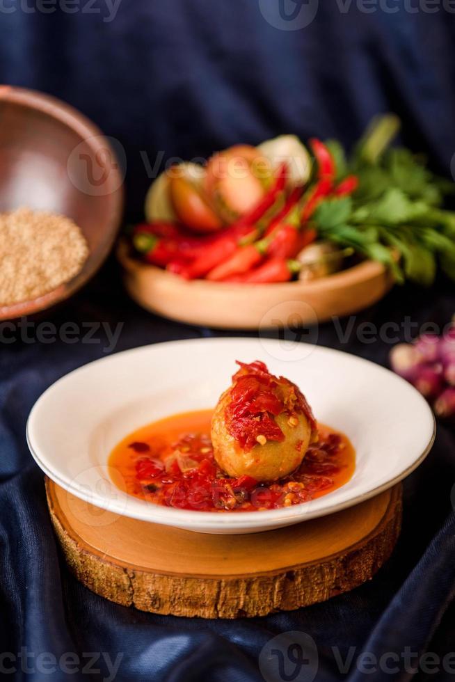 oeufs avec sauce chili rouge sur le plat. œufs de balado. nourriture indonésienne photo