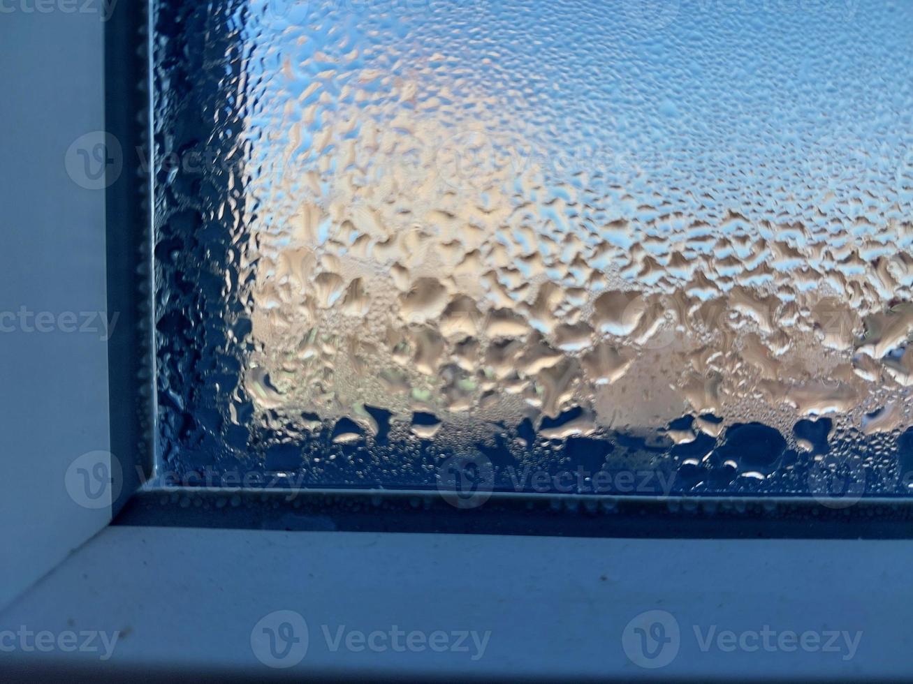 fenêtre recouverte de gouttes gelées d'eau de condensation photo