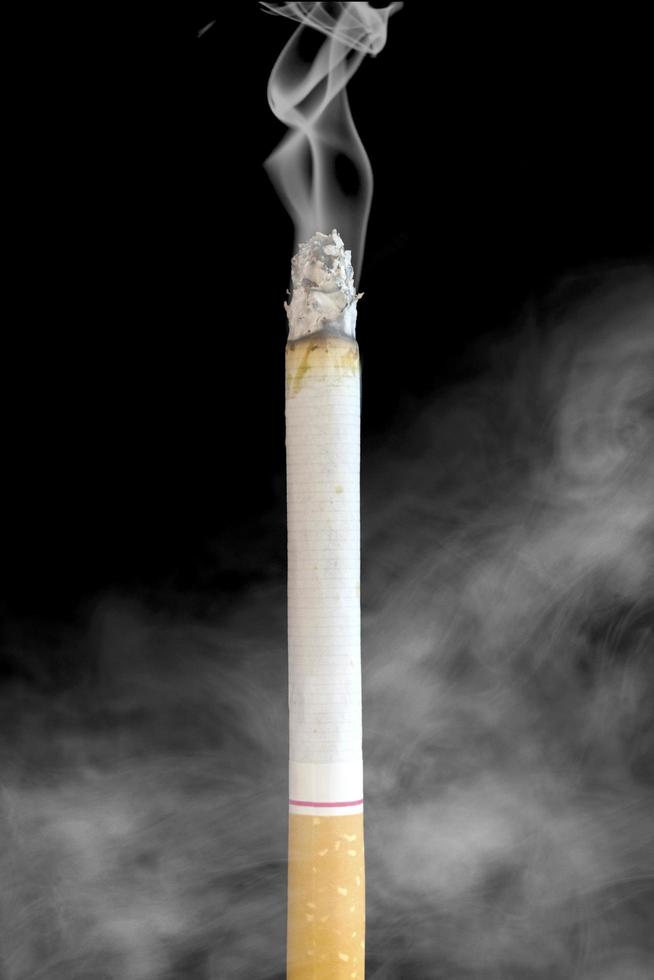 une cigarette debout isolée avec de la fumée photo