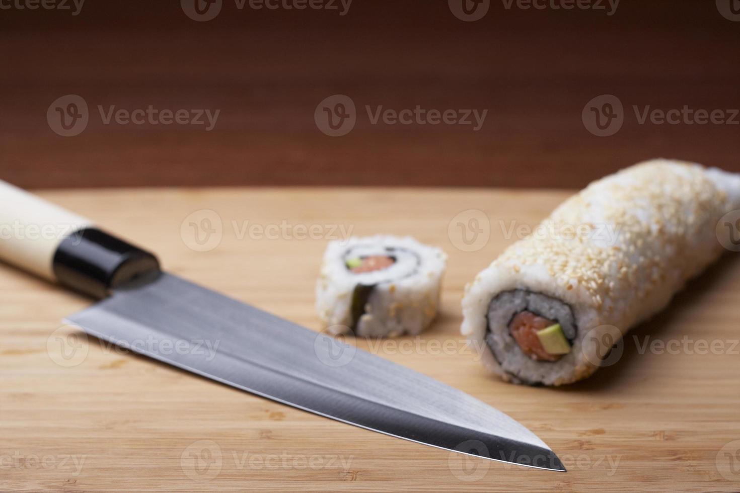 sushi et couteau sur une planche à découper en bois photo