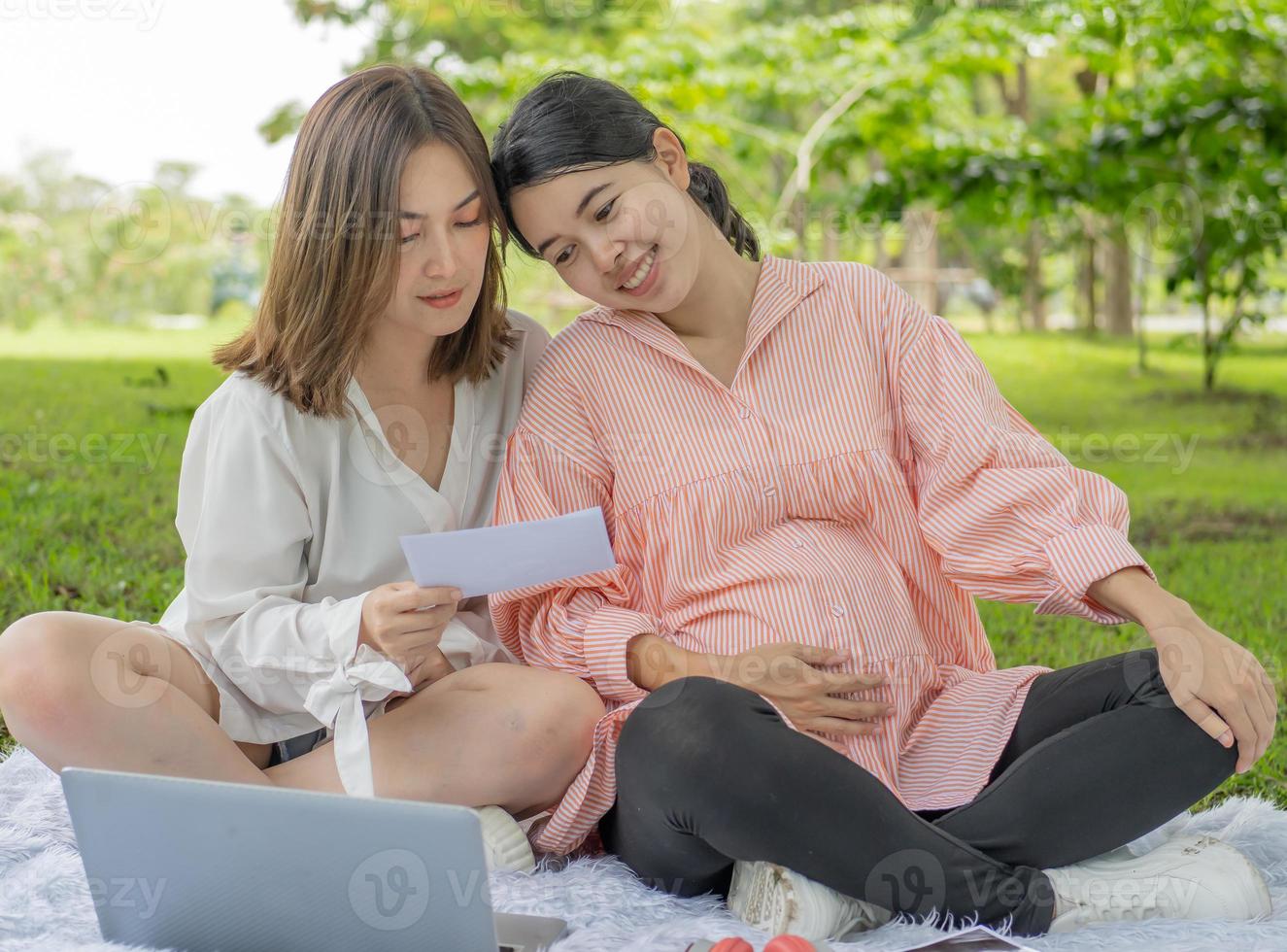 famille lesbienne heureuse femme enceinte se détendre dans le parc. les homosexuels ont une relation affectueuse comme un couple marié. personne homosexuelle a l'égalité d'être parent. mode de vie maternité grossesse lgbtq. photo