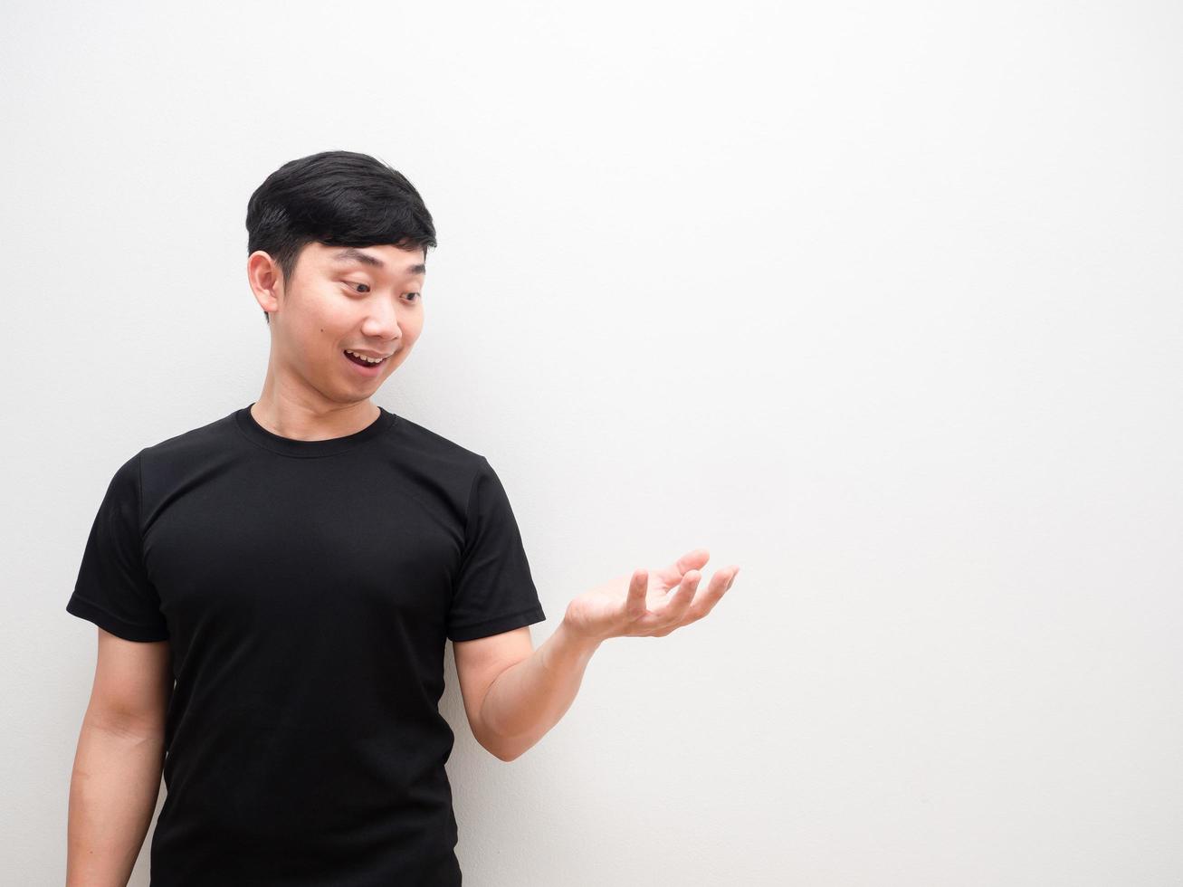 homme asiatique regarde la main gauche avec un sourire heureux sur l'espace de fond blanc photo