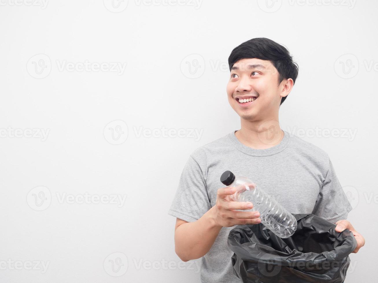 l'homme met la bouteille en plastique à la poubelle et regarde l'espace de copie photo