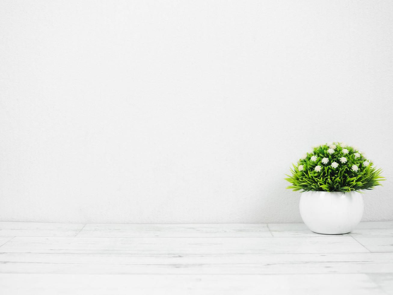 petit vase sur table en bois et fond de mur blanc copie espace style minimal photo