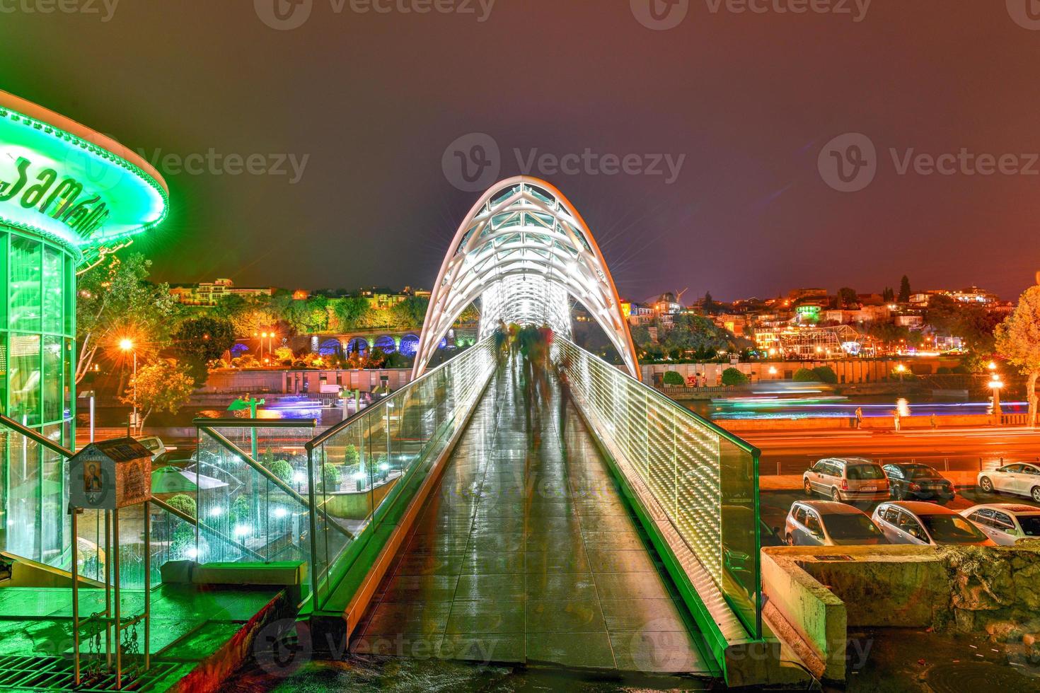 le pont de la paix à tbilissi, un pont piétonnier sur la rivière mtkvari à tbilissi, géorgie illuminée la nuit. photo