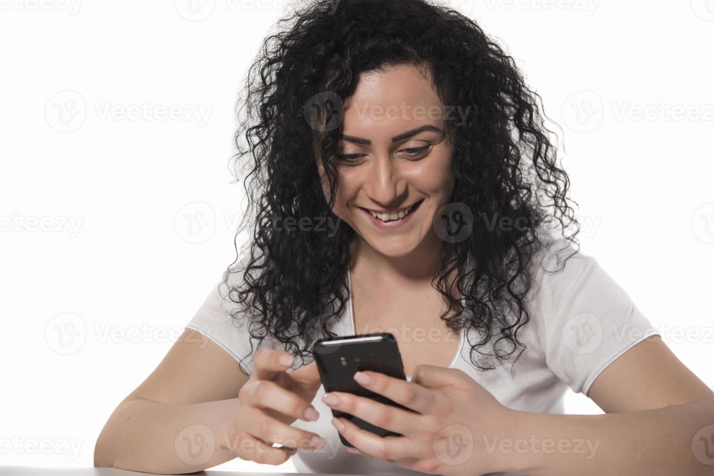 Portrait d'une femme heureuse à l'aide de téléphone mobile isolé sur fond blanc photo