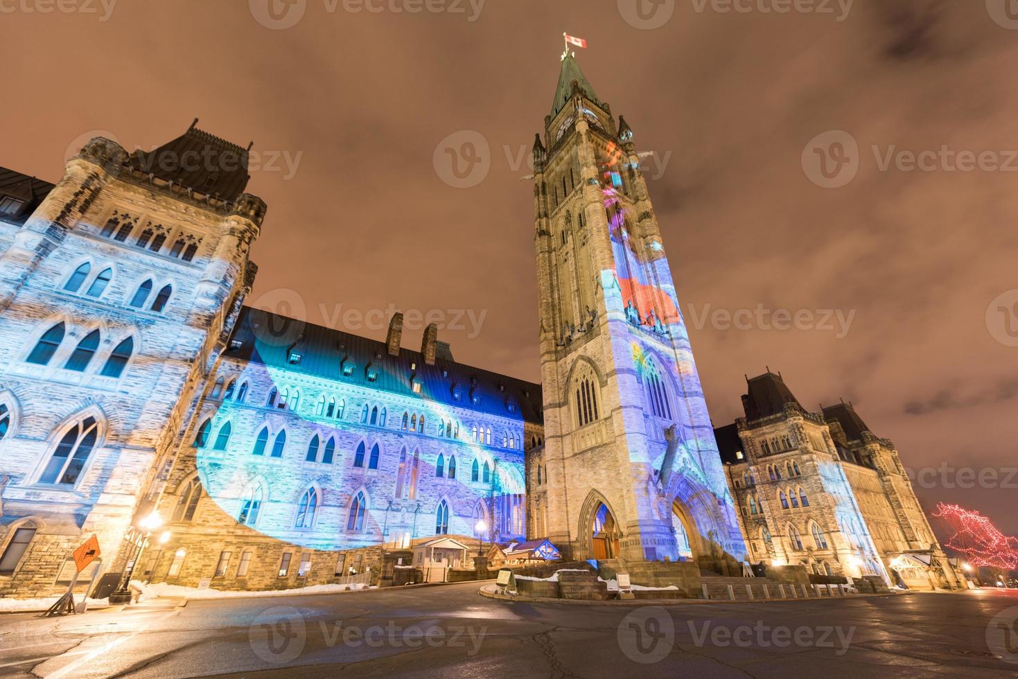 spectacle de lumière des fêtes d'hiver projeté la nuit sur la maison du parlement canadien pour célébrer le 150e anniversaire du canada à ottawa, canada. photo