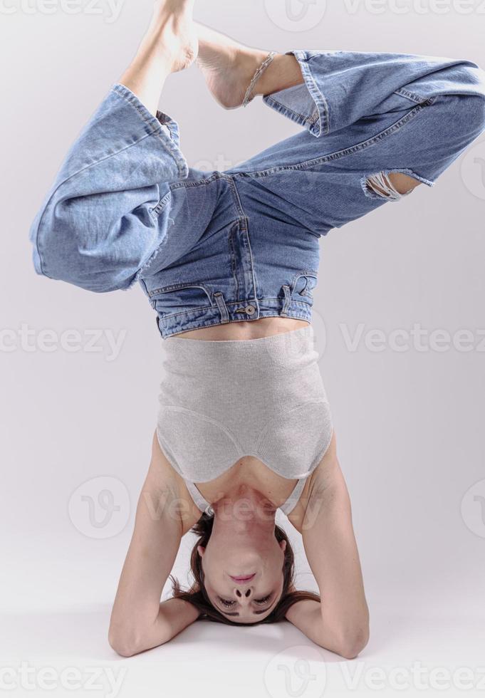 portrait d'une belle jeune femme avec un corps athlétique flexible faisant des étirements de jambe. isolée photo