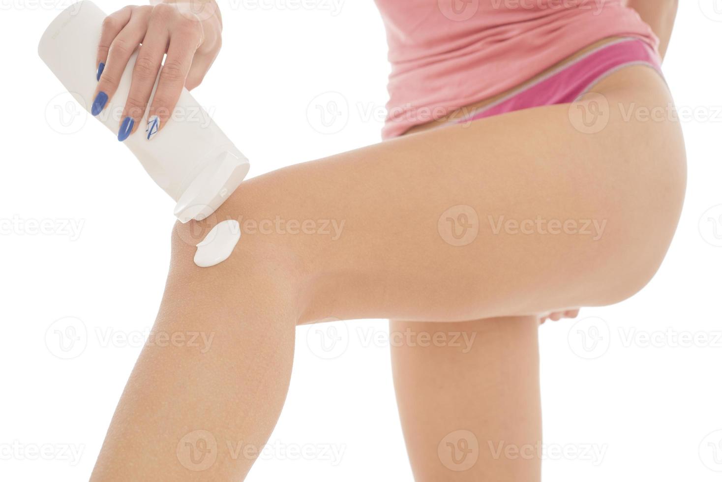 soin du corps. femme appliquant de la crème sur les jambes. femme appliquant une crème anti-cellulite photo