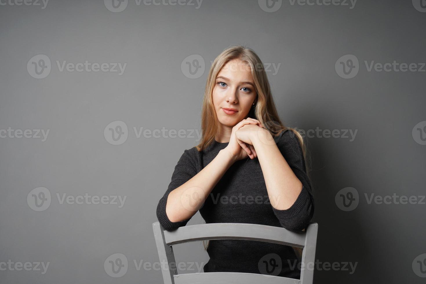 jeune femme sereine assise à califourchon sur une chaise photo