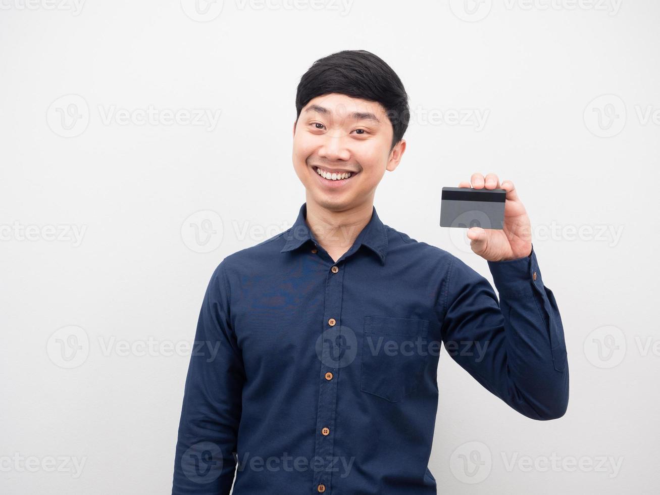 homme asiatique tenant une carte de crédit émotion heureuse et souriant photo