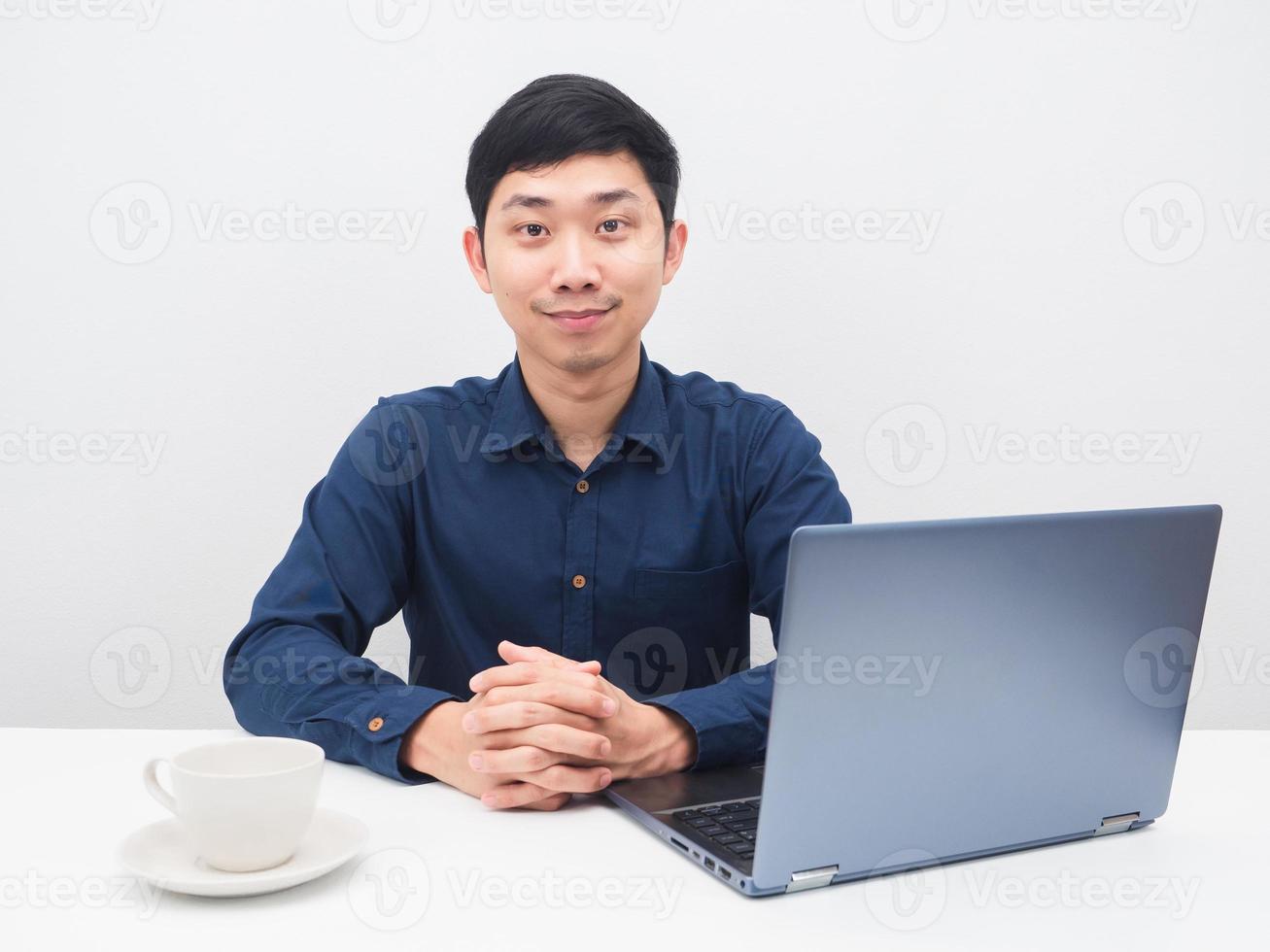 homme asiatique sur le lieu de travail sur un ordinateur portable de table et une tasse de café sourire en regardant la caméra photo