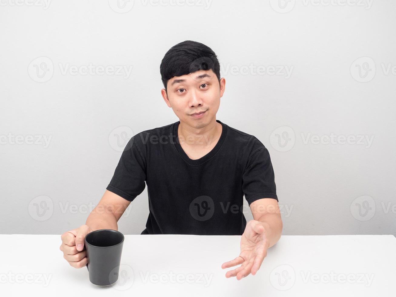 homme assis à table avec un geste de tasse de café suggérer photo