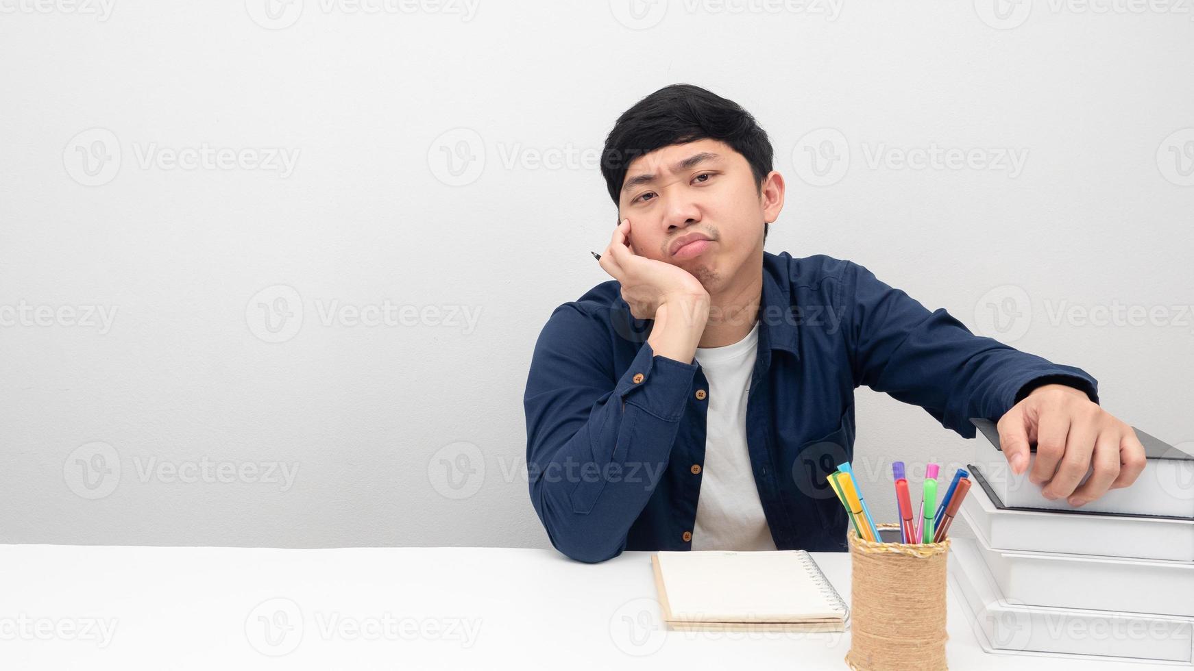 geste de l'homme ennuyé de travailler et de lire un livre sur l'espace de copie de table photo