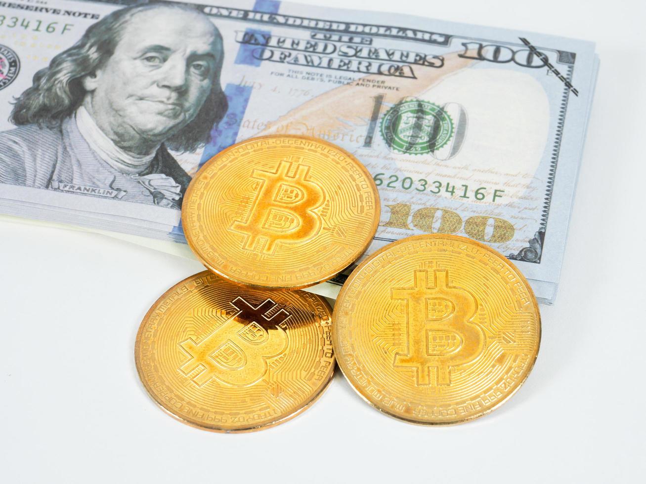 gros plan des bitcoins dorés et de l'argent en dollars fond blanc, le concept d'argent numérique photo