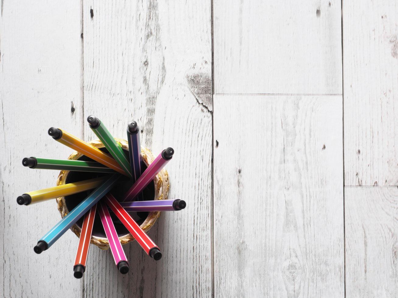 De nombreux cercles colorés de stylos dans une boîte sur une table en bois et la lumière naturelle du concept d'idée de soleil vue de dessus, affaires et éducation photo