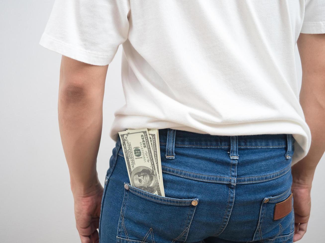 Close up dos de l'homme de l'argent dollar en pantalon poche de jean portrait fond blanc photo