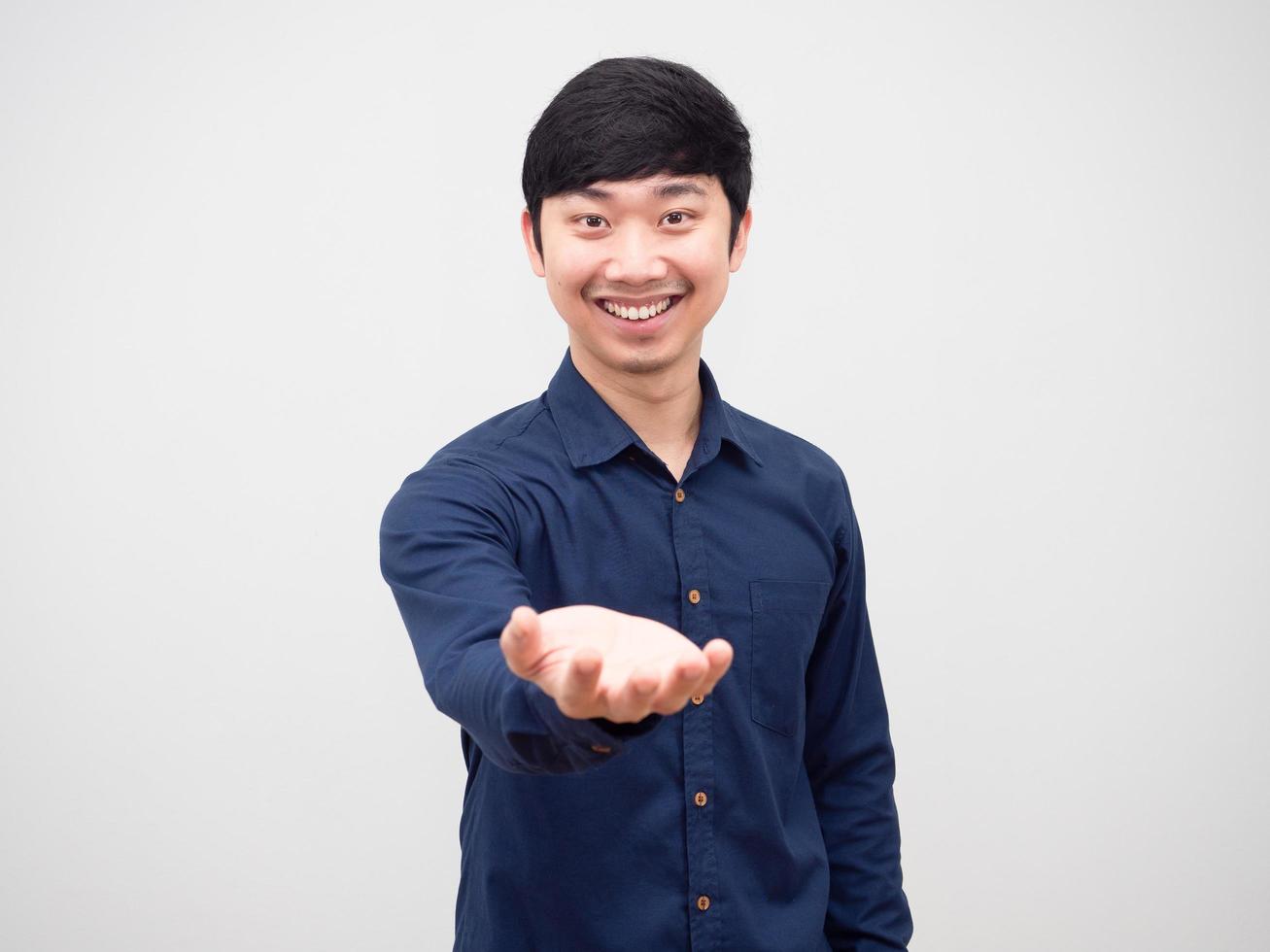 homme gai sourire et montrer une main vide sur fond blanc photo