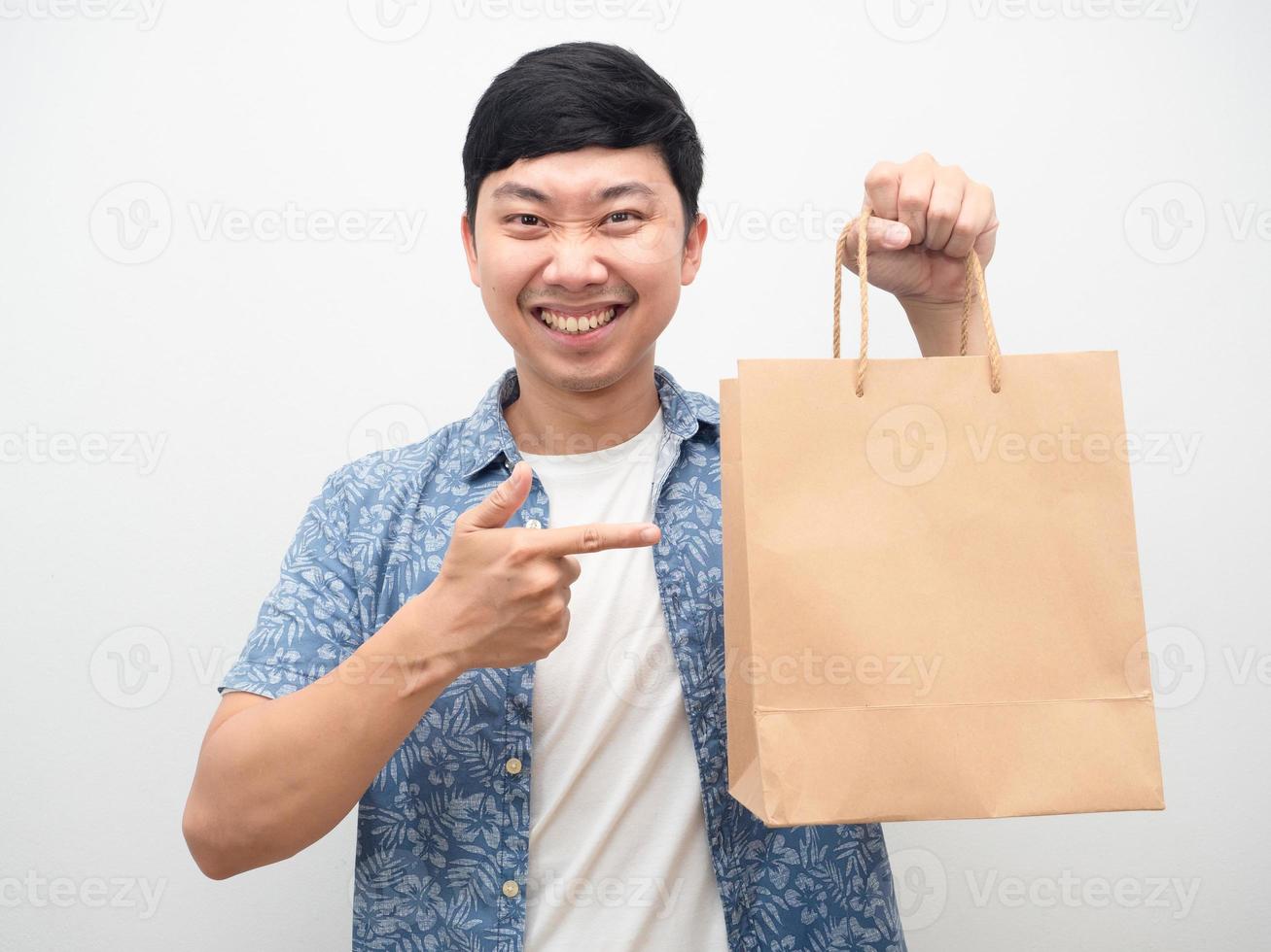 Portrait man smiling pointer du doigt le sac à provisions à la main photo