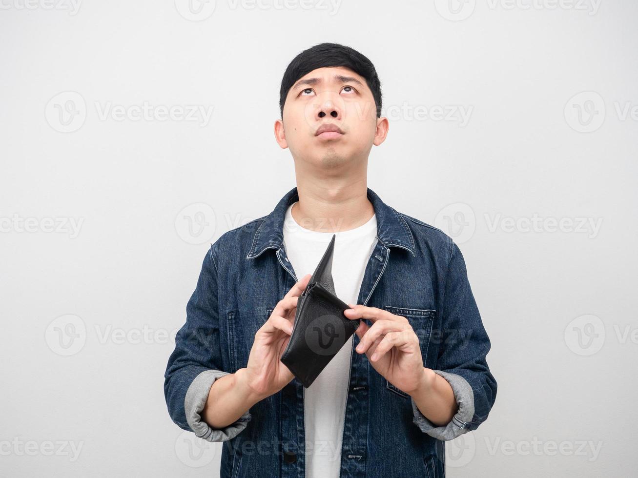 homme se sentant triste de ne pas avoir d'argent tenant son portefeuille à la main levant les yeux photo