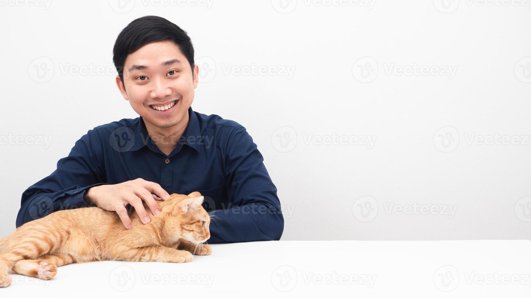 homme avec un joli chat de couleur orange joyeux sur l'espace de copie de table photo