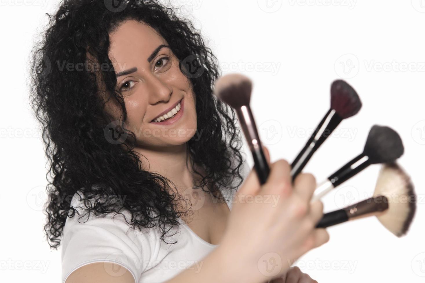 portrait en gros plan d'une femme avec un pinceau de maquillage près du visage photo