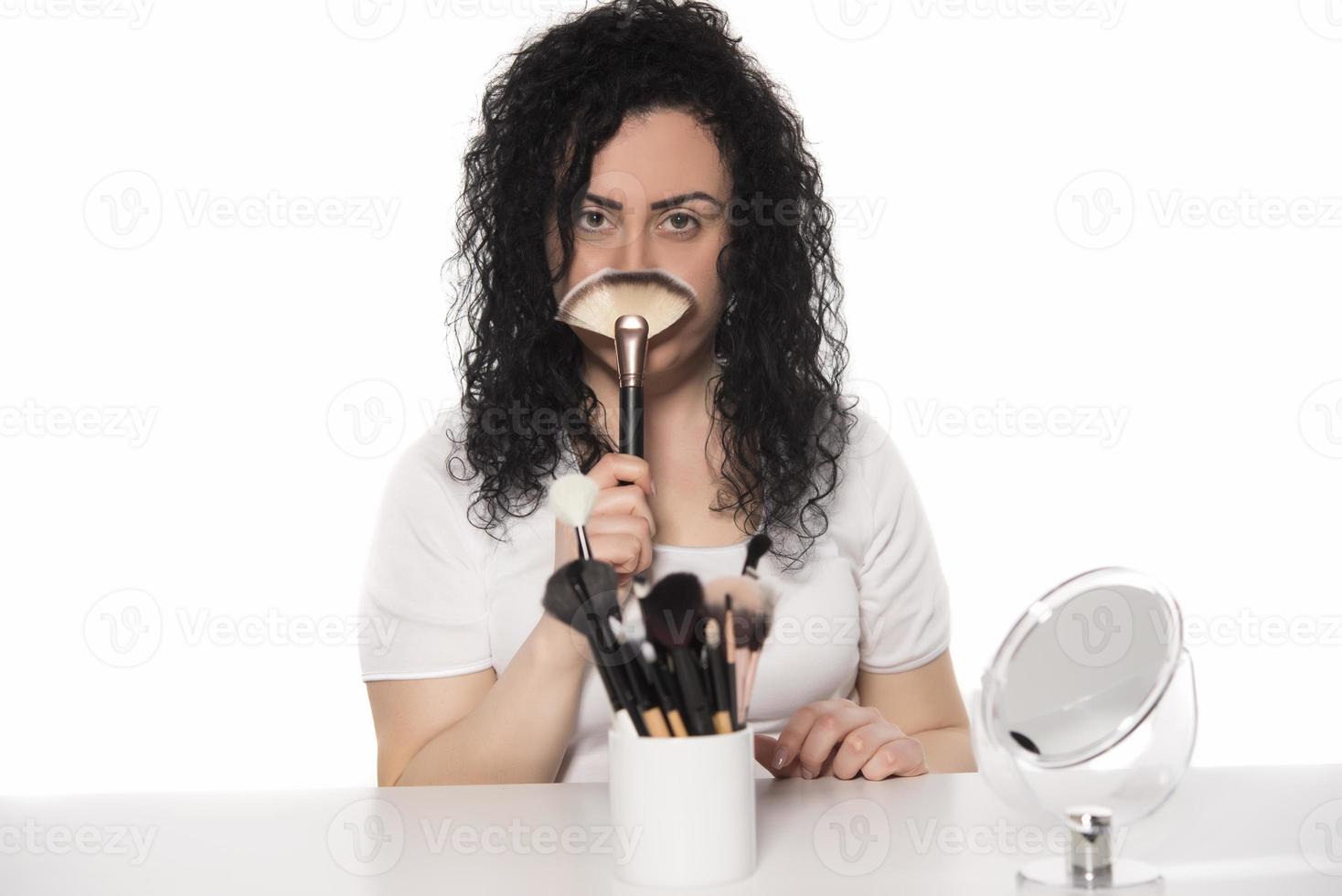 portrait en gros plan d'une femme avec un pinceau de maquillage près du visage photo