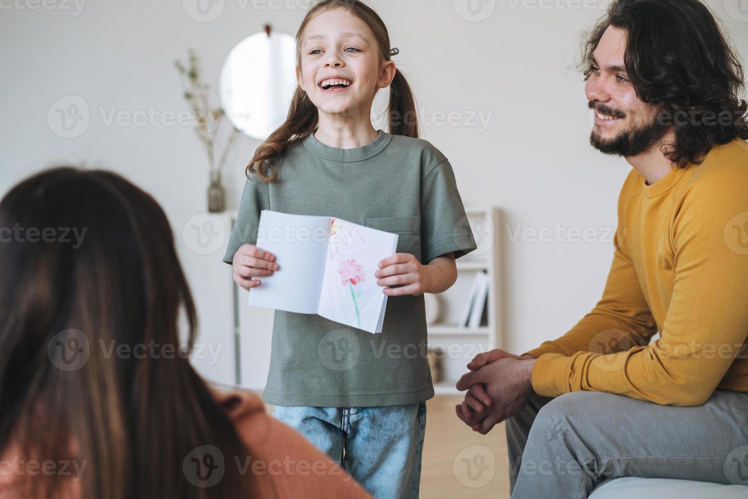 jeune famille heureuse avec enfant fille s'amusant dans le salon à la maison, fête des mères photo