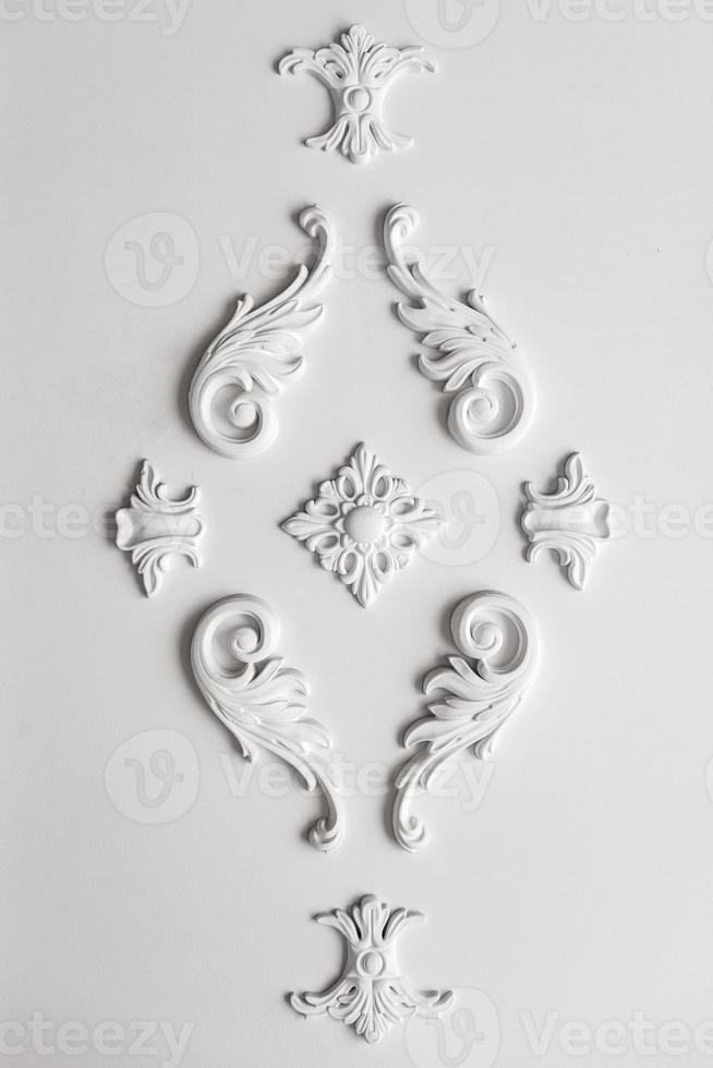 intérieur cher. décor de gypse au mur. éléments en stuc sur un mur de luxe léger. à motifs blancs. élément mouluré en gypse. style rococo photo