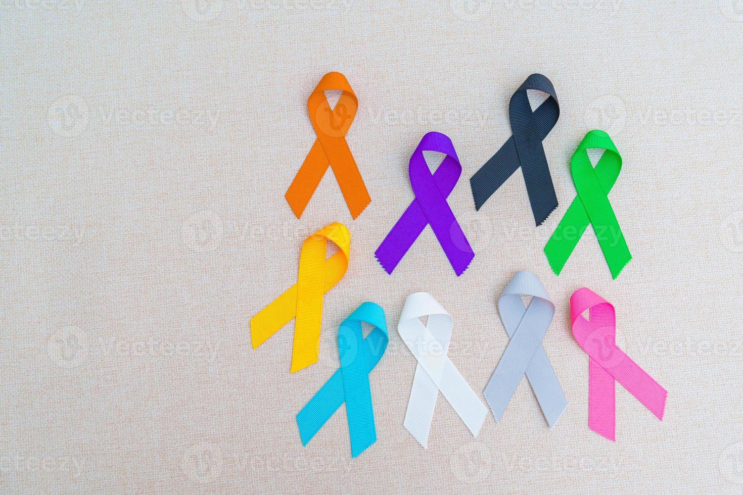 journée mondiale du cancer, 4 février. rubans colorés pour soutenir les personnes vivant et malades. soins de santé, combats, journée médicale et nationale de survie au cancer, concept de journée de sensibilisation à l'autisme photo