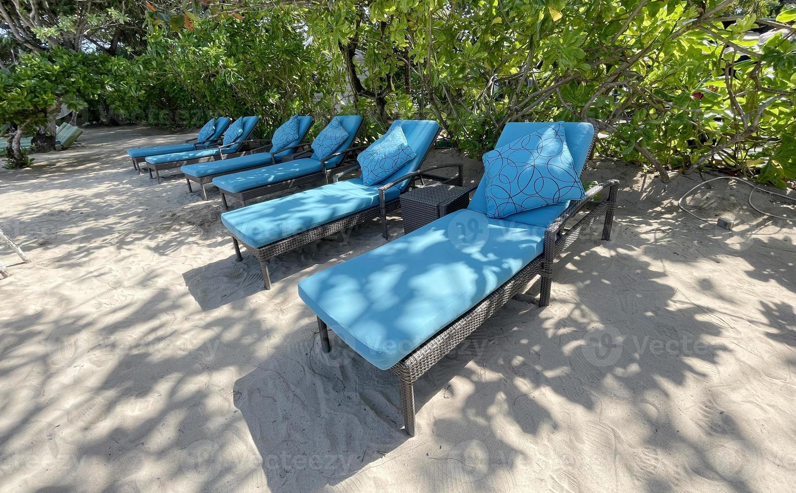 chaises longues ou chaises de plage sur la plage de sable blanc lors d'une chaude journée d'été dans un hôtel tropical de luxe photo