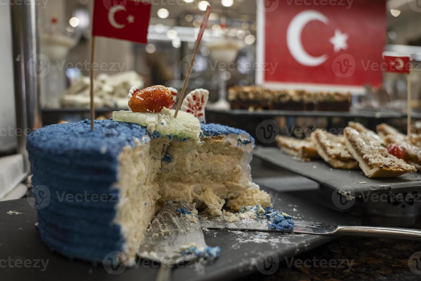 gâteau en couches à moitié mangé avec des tranches de fruits et de la crème fouettée bleue sur la table photo