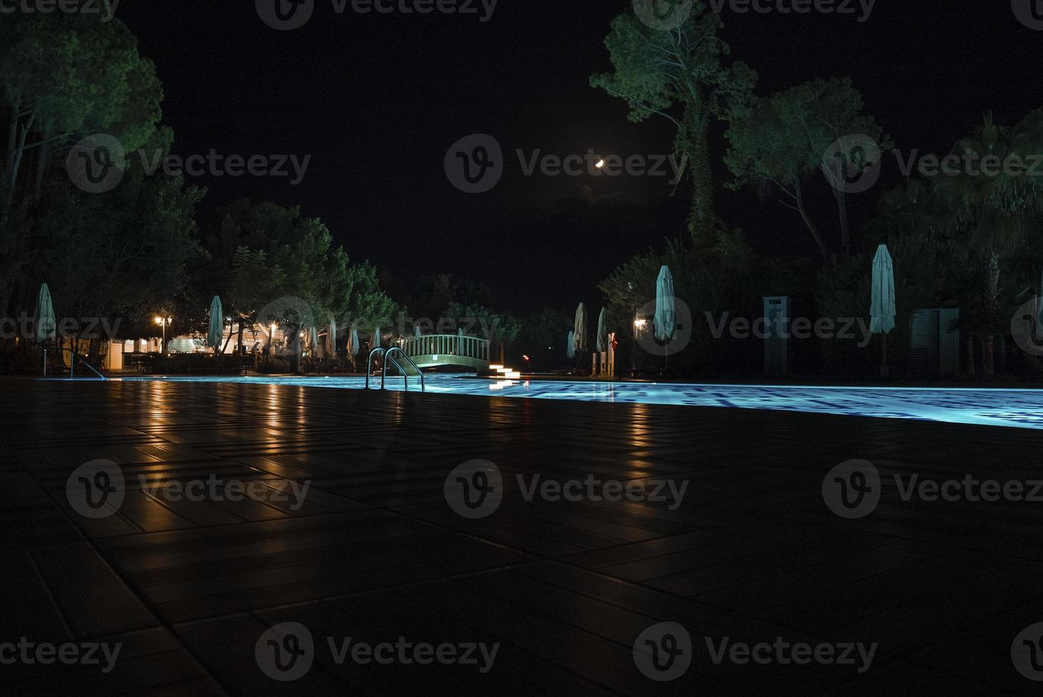 vue sur la piscine illuminée la nuit dans la station touristique photo