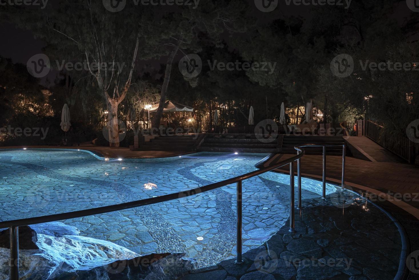 garde-corps par piscine illuminée la nuit dans la station touristique photo