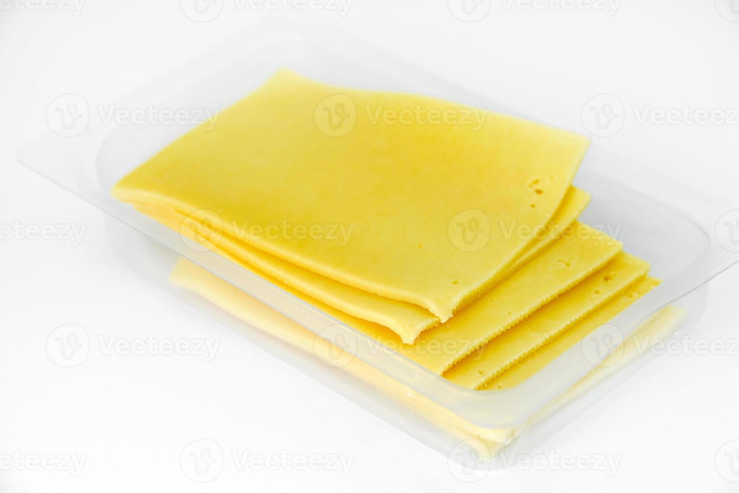 fines tranches de fromage sur un support en plastique. délicieux fromage jaune haché. fromage dans un emballage du magasin. photo