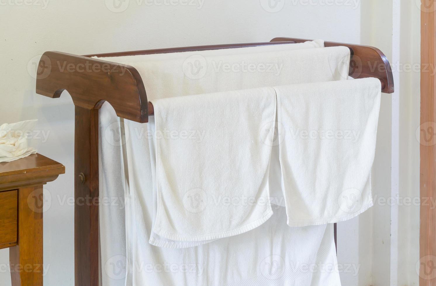serviettes de bain blanches après l'utilisation par les clients accrochées sur une corde à linge en bois dans le complexe ou la chambre d'hôtel photo