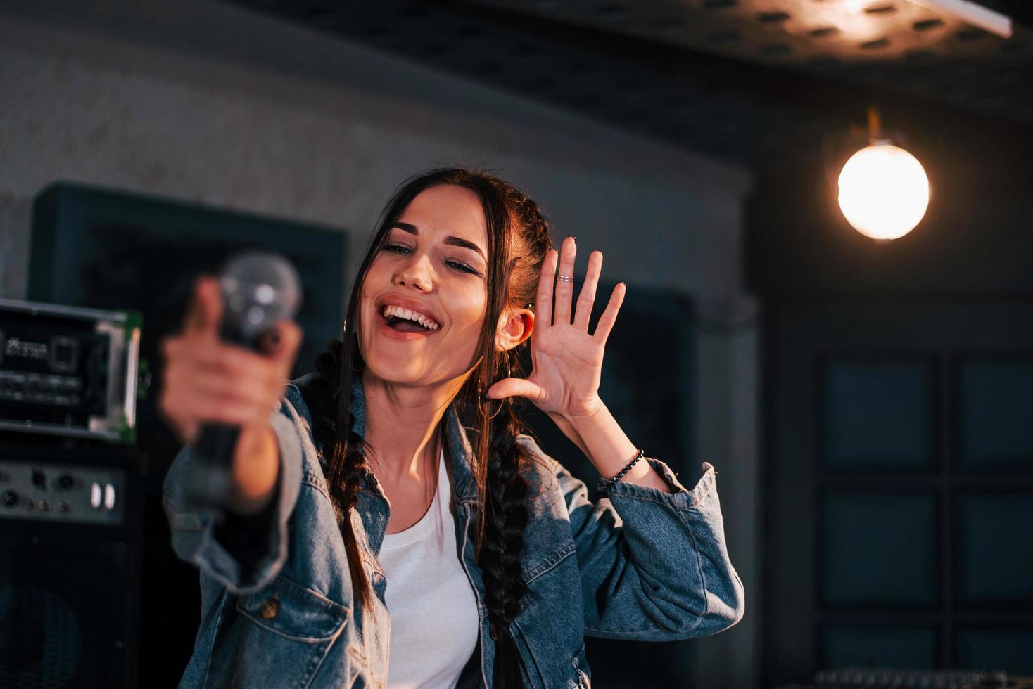 jeune belle interprète féminine répétant dans un studio d'enregistrement photo