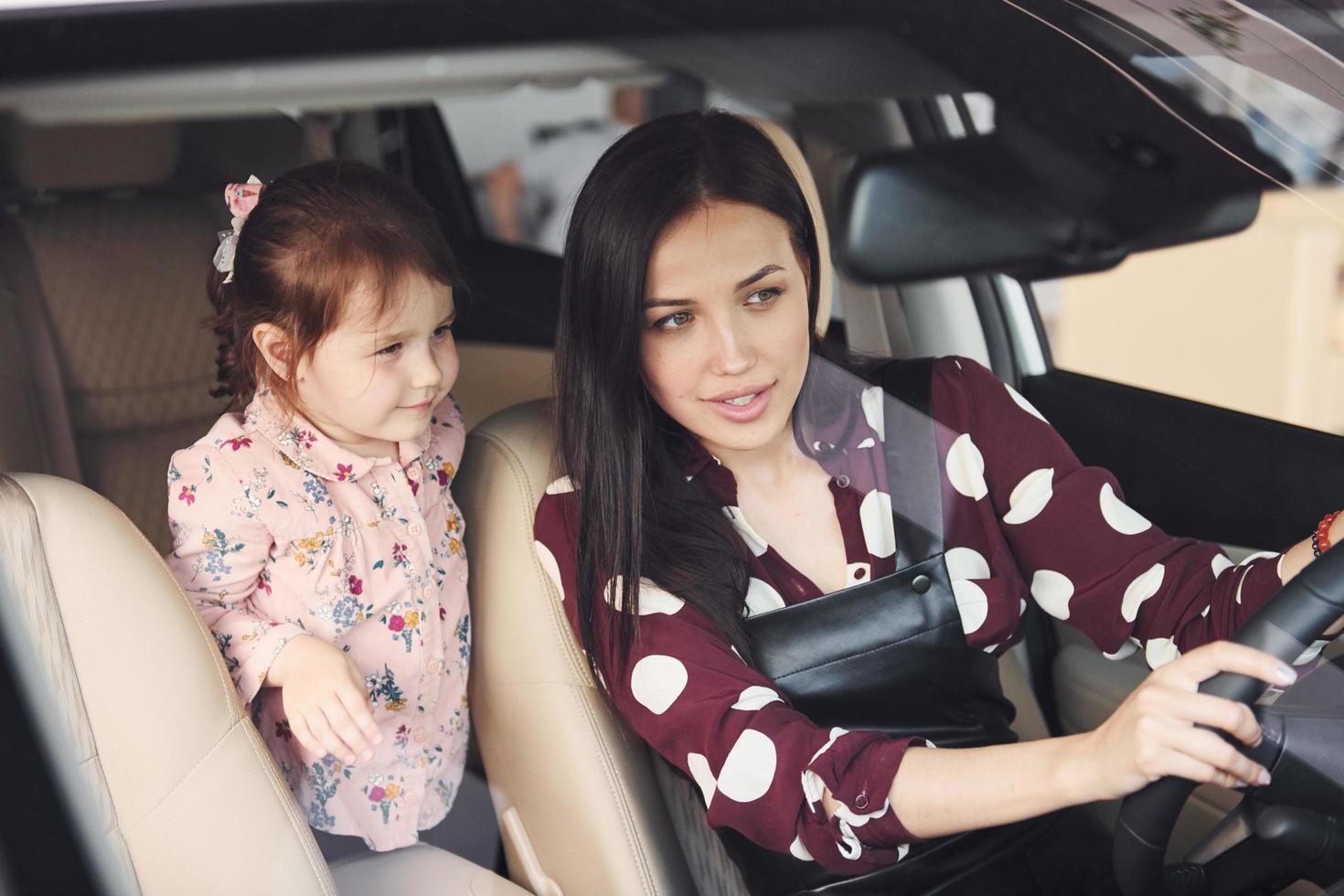 mère avec sa fille à l'intérieur de l'automobile moderne ensemble photo