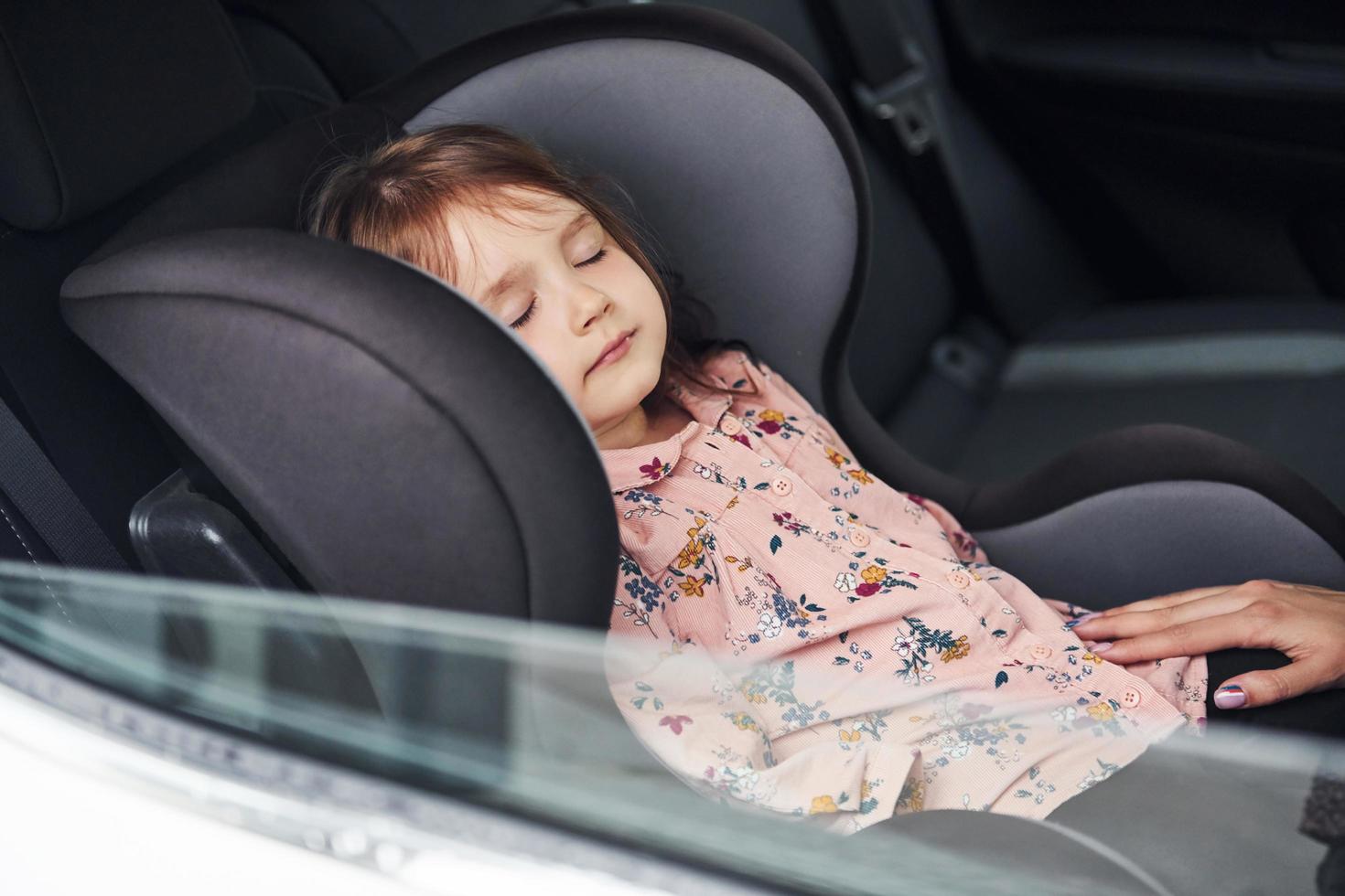 jolie petite fille dormant à l'intérieur de la voiture. conception du voyage et des vacances photo
