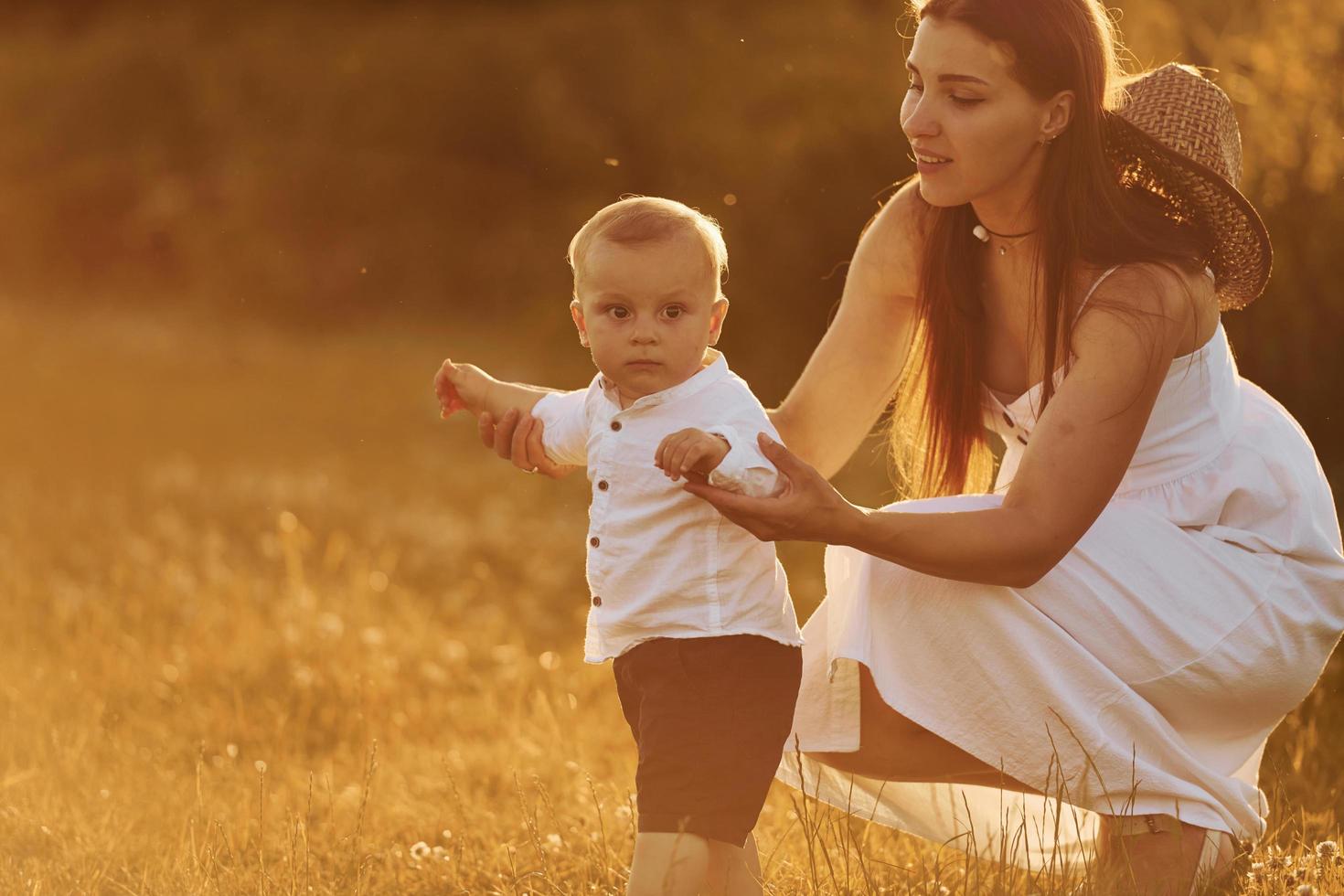 mère heureuse avec son fils passant du temps libre sur le terrain à l'heure ensoleillée de l'été photo