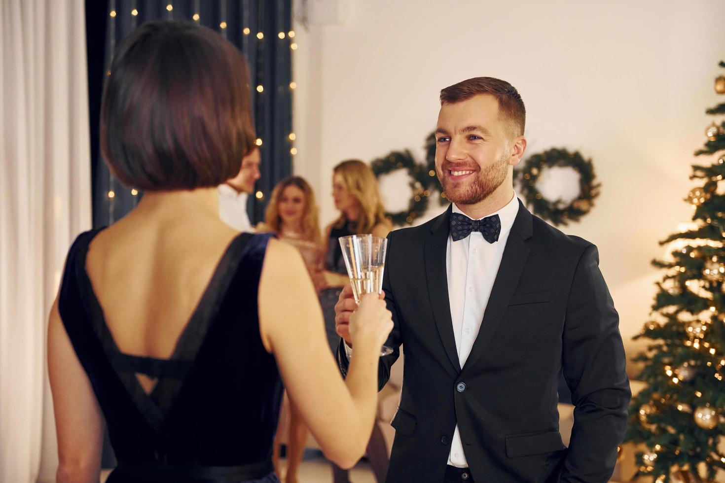 avoir une conversation. un groupe de personnes organise une fête du nouvel an à l'intérieur photo