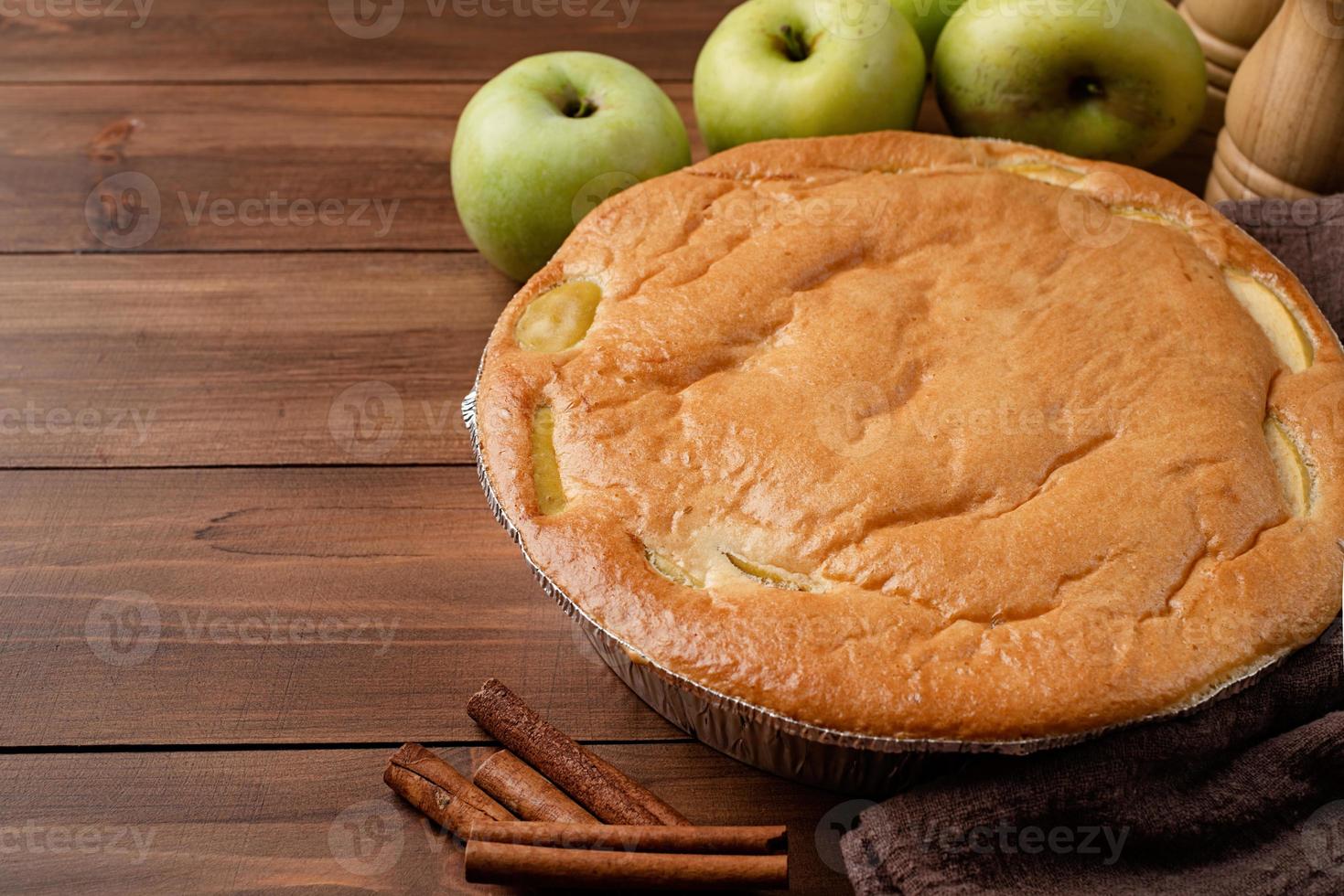 tarte aux pommes charlotte sur table en bois avec pomme fraîche et cannelle photo