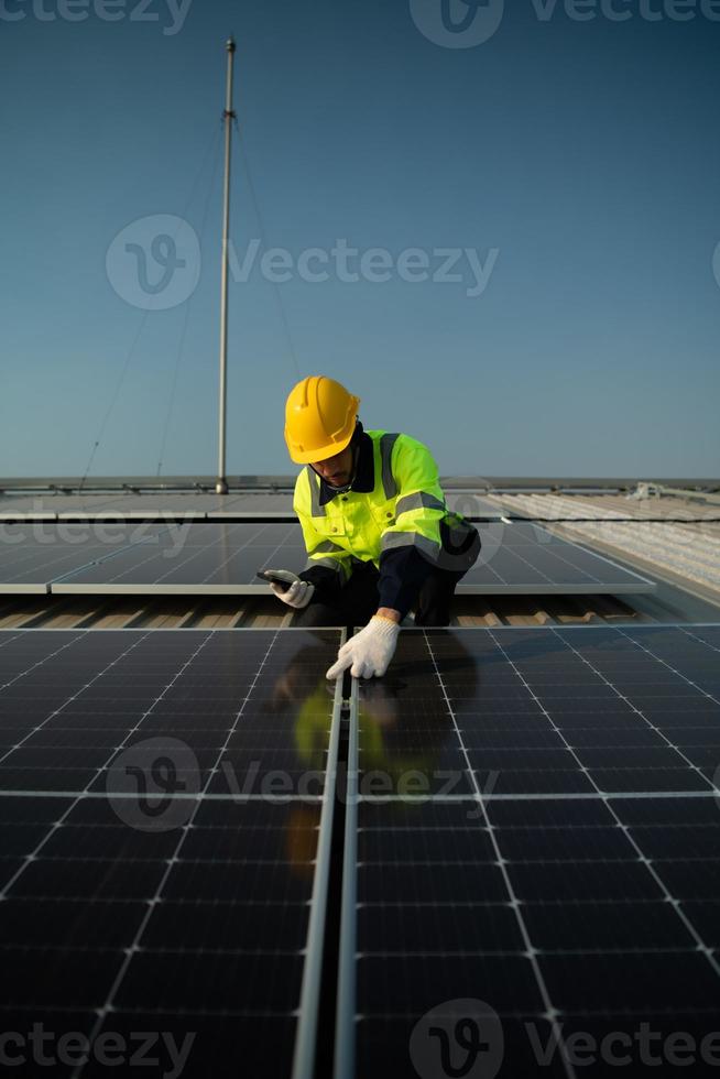 les techniciens fournissent des services de maintenance trimestriels des cellules solaires sur le toit de l'usine photo