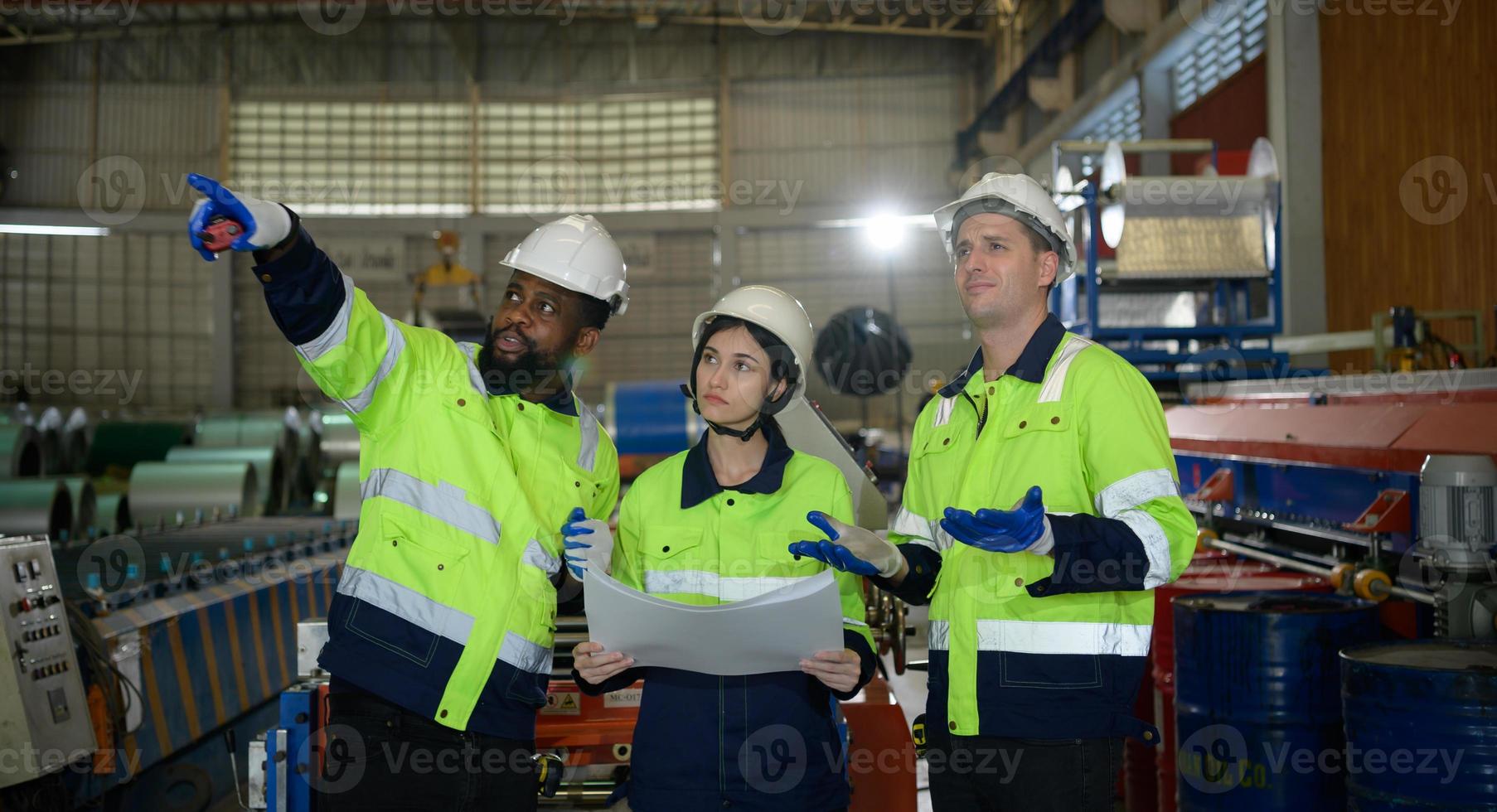 jeune ingénieure apprenant à faire fonctionner des machines dans une usine avec des ingénieurs chevronnés photo