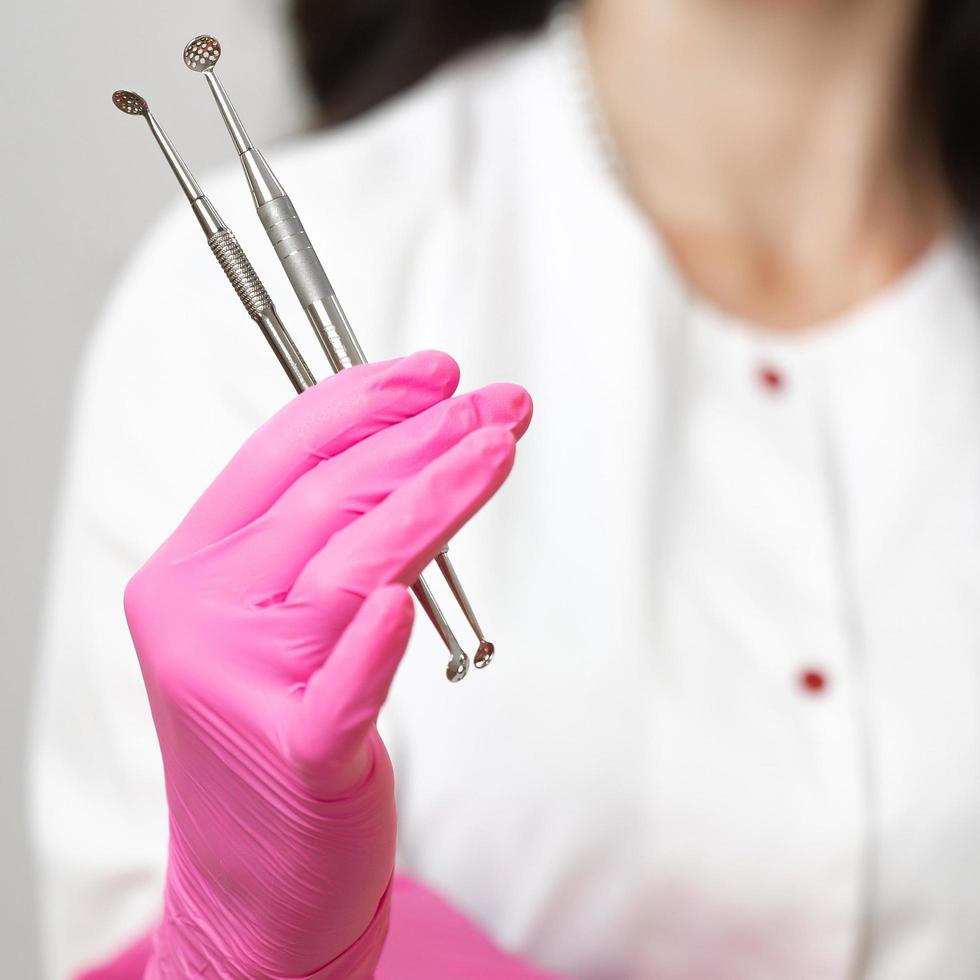 cuillères uno entre les mains d'un cosmétologue, outils d'un cosmétologue pour nettoyer le visage. photo