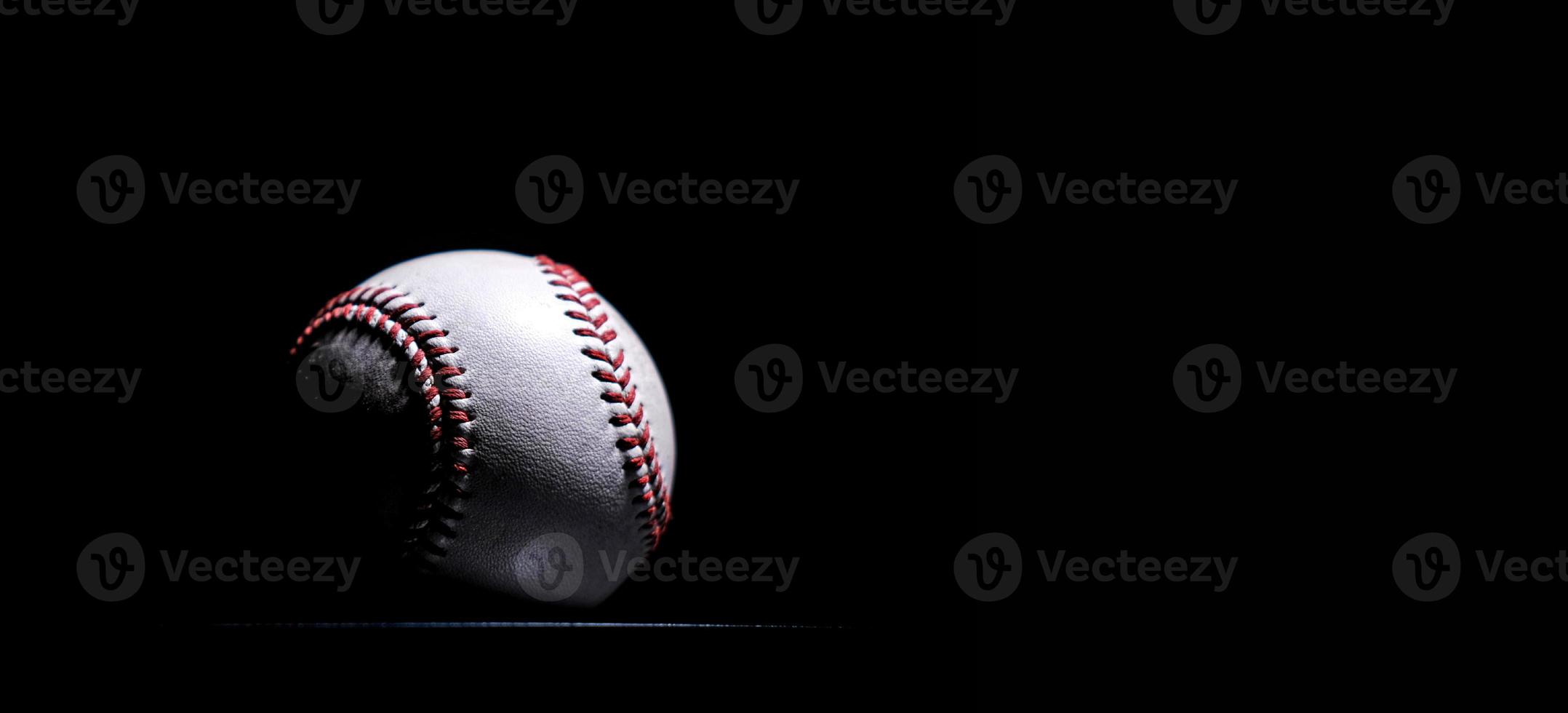 poses de baseball en cuir blanc sur fond noir. photo